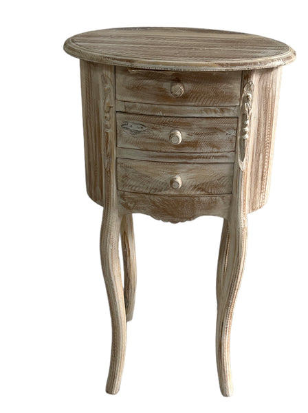 Oval 3-drawer bedside table made of white washed teak with a distressed finish.