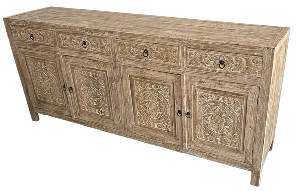 A Teak wooden buffet cabinet with carved designs on the doors, featuring four drawers and four doors, with a white washed finish.side view